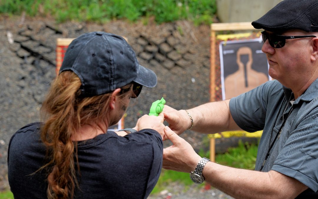 Man training woman for proper way to shoot firearm at target