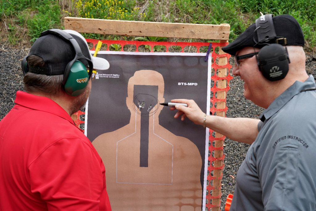 man pointing at shooting target while smiling