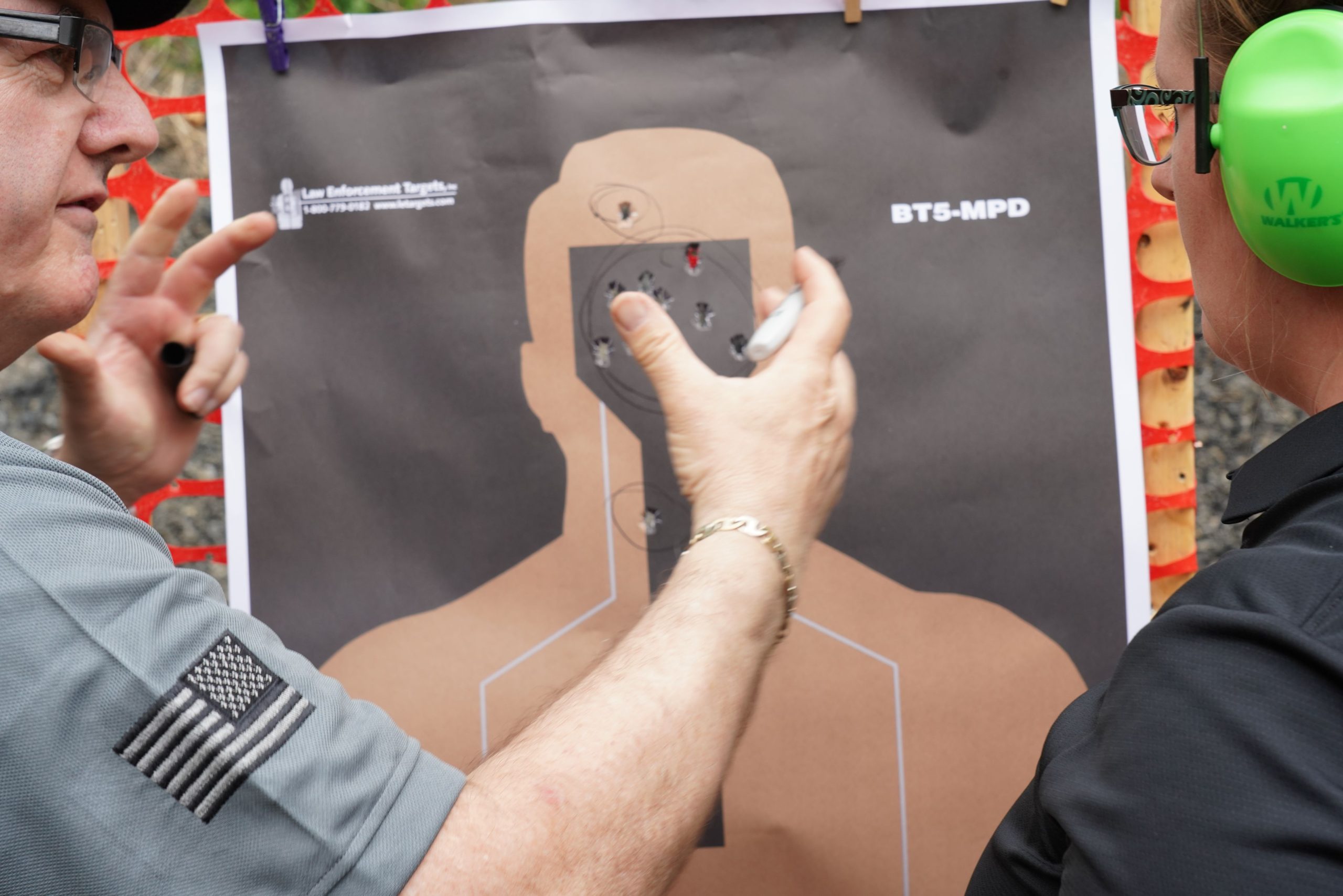 man explaining shooting target to another man